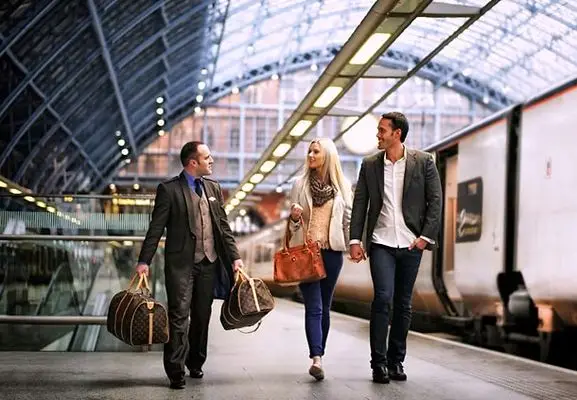 Chauffeur privé aéroport Val d'Isère portant les bagages d'un couple sur le quai de la gare